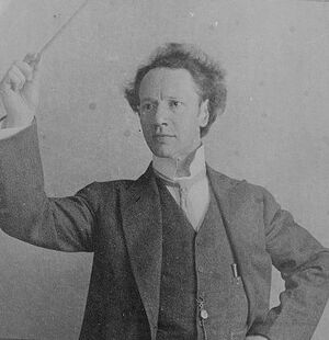 Ossip Gabrilowitsch posing with a conductor’s baton. Cropped digital image from original glass negative. Source: Bain News Service, “Gabrilowitsch.” Public domain, https://www.loc.gov/item/2014710518/, via Library of Congress.