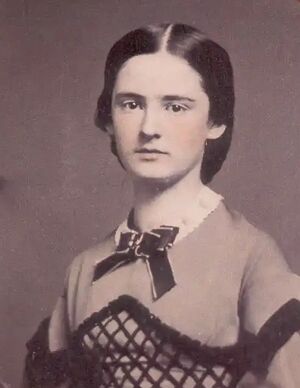 Monochrome portrait of Olivia Langdon, aged about 22, with some colorization of the face. Cropped. Source: “Olivia Louise Langdon (c.1867),” https://marktwainstudies.com/wp-content/uploads/2025/04/Early-oval-of-OLL-copy.webp, courtesy of the Mark Twain House and Museum, Hartford, CT.